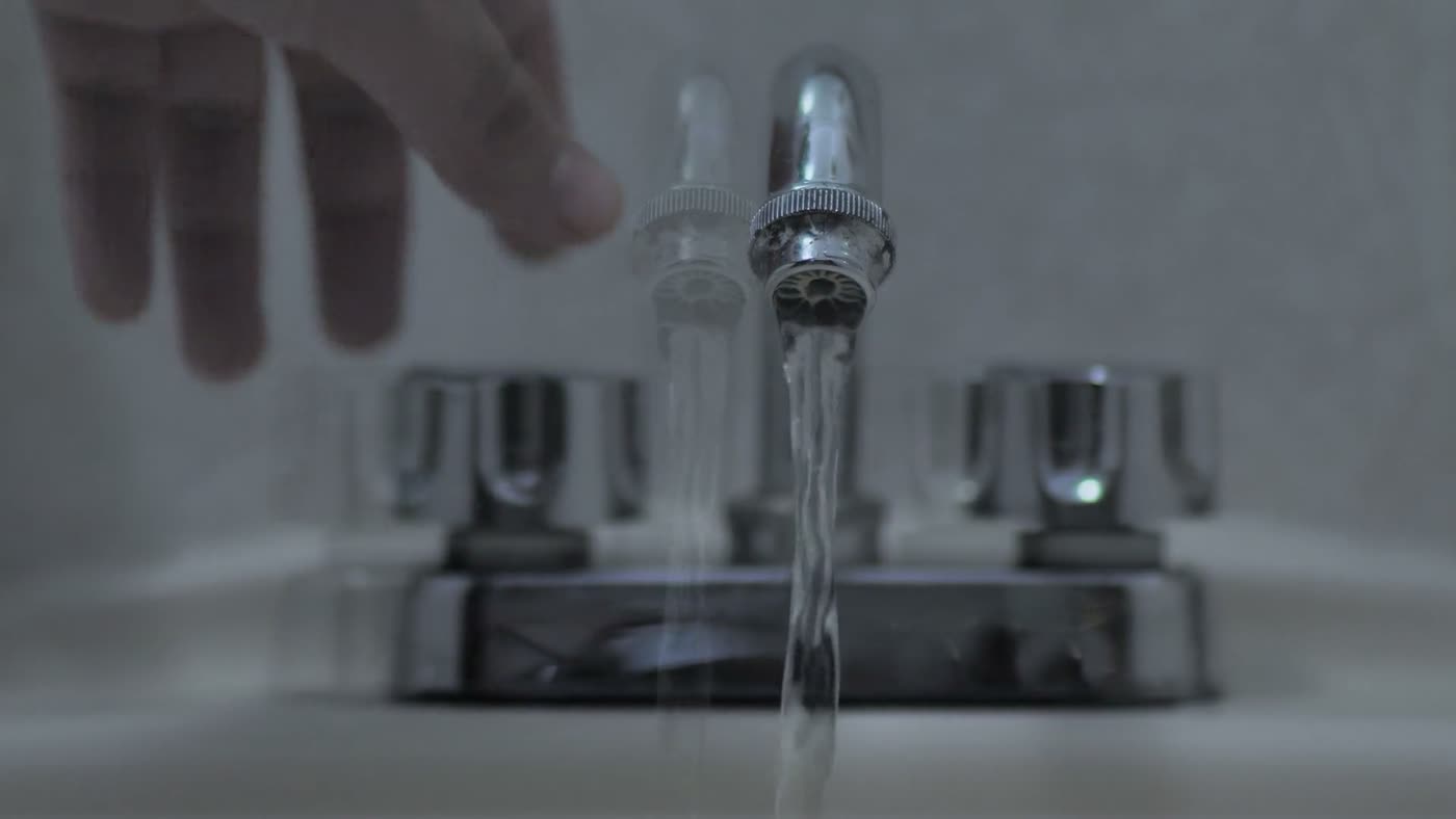 Water running from a chrome bathroom faucet